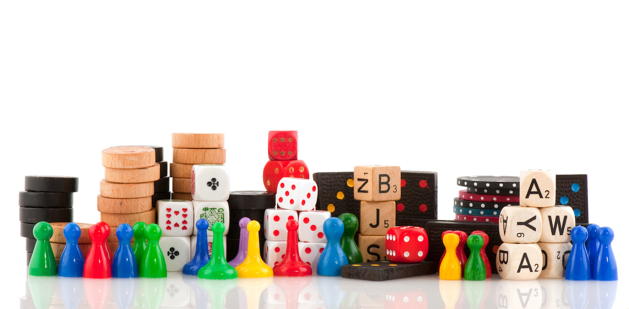 An image of various game pieces from different games like dice, dominoes, poker chips, etc.