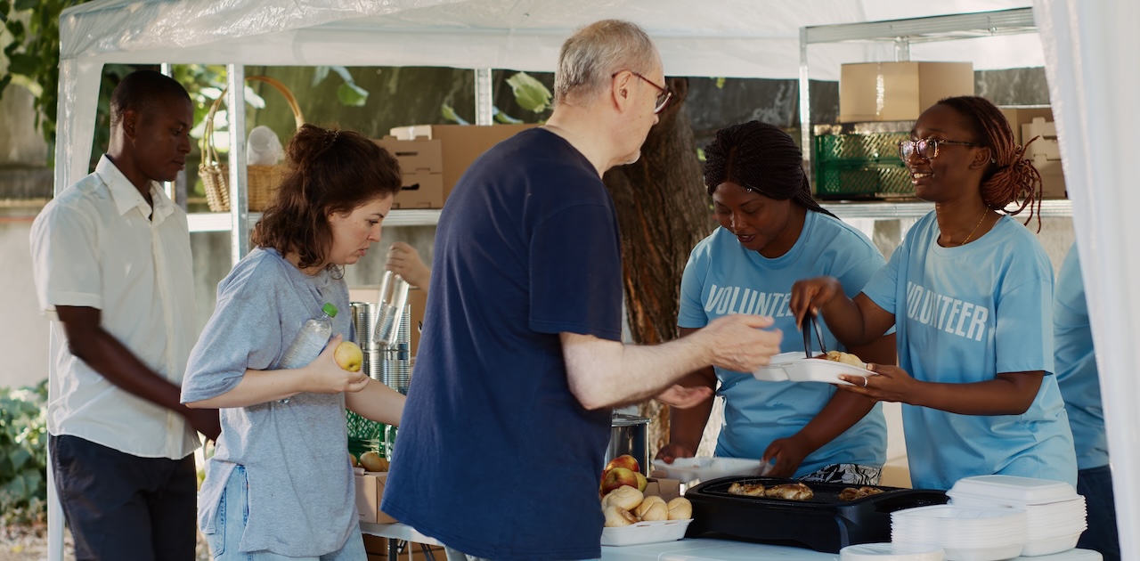 Volunteers serving food in a food line.