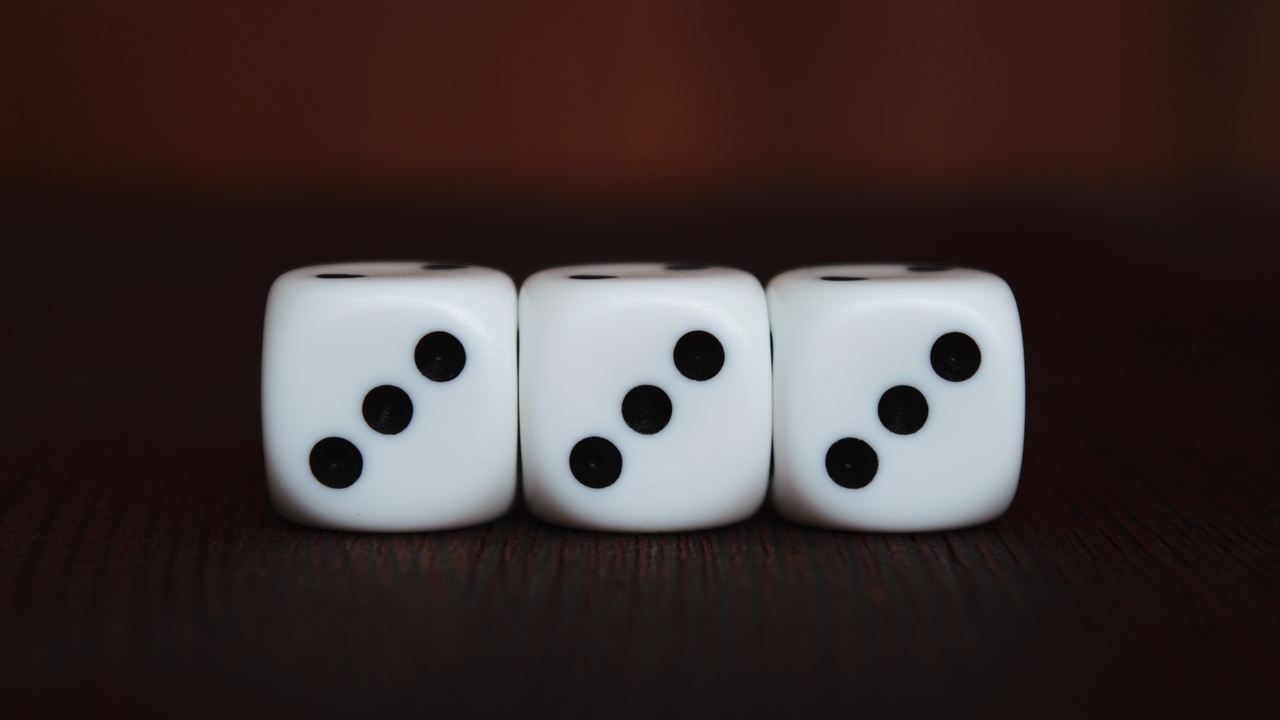 Three dice in a row each showing the value of three.