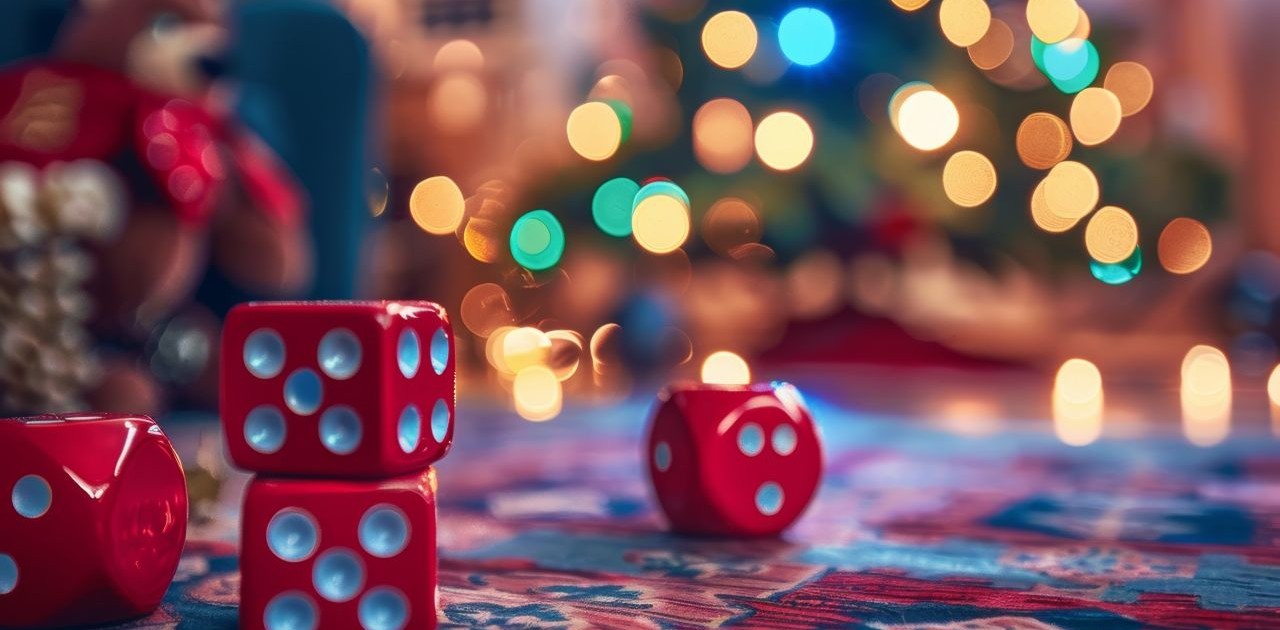 Red dice on a festive holiday table with a blurred Christmas tree and glowing lights in the background, creating a warm and cozy Bunco party atmosphere.