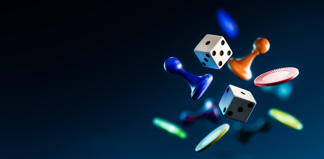Dice thrown in mid-air with poker chips and other game pieces.